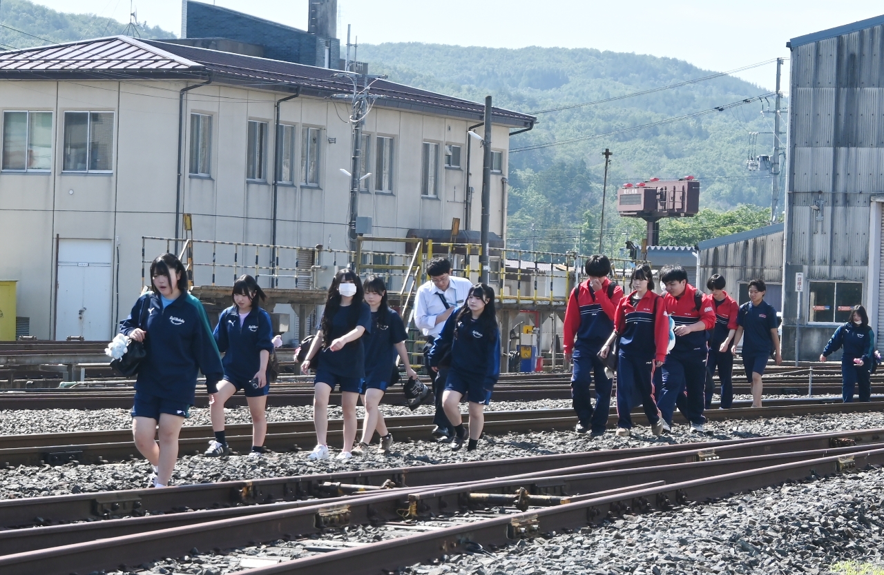 線路を歩いて久慈駅に到着した高校生ら=25日午前8時50分ごろ、久慈市