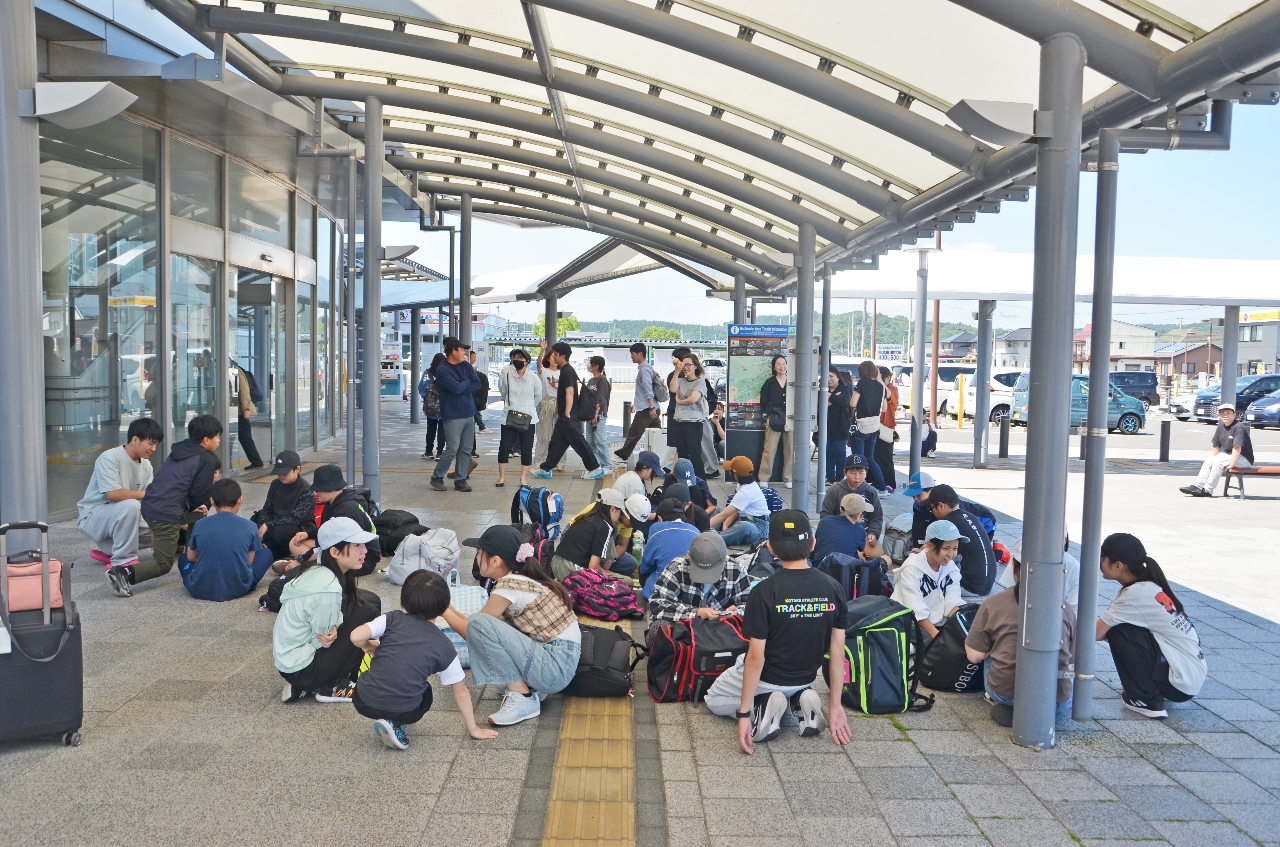 修学旅行で北海道に向かう予定だった八戸市立多賀台小の6年生。八戸駅西口で東北新幹線の運転再開を待った=25日午前9時40分ごろ