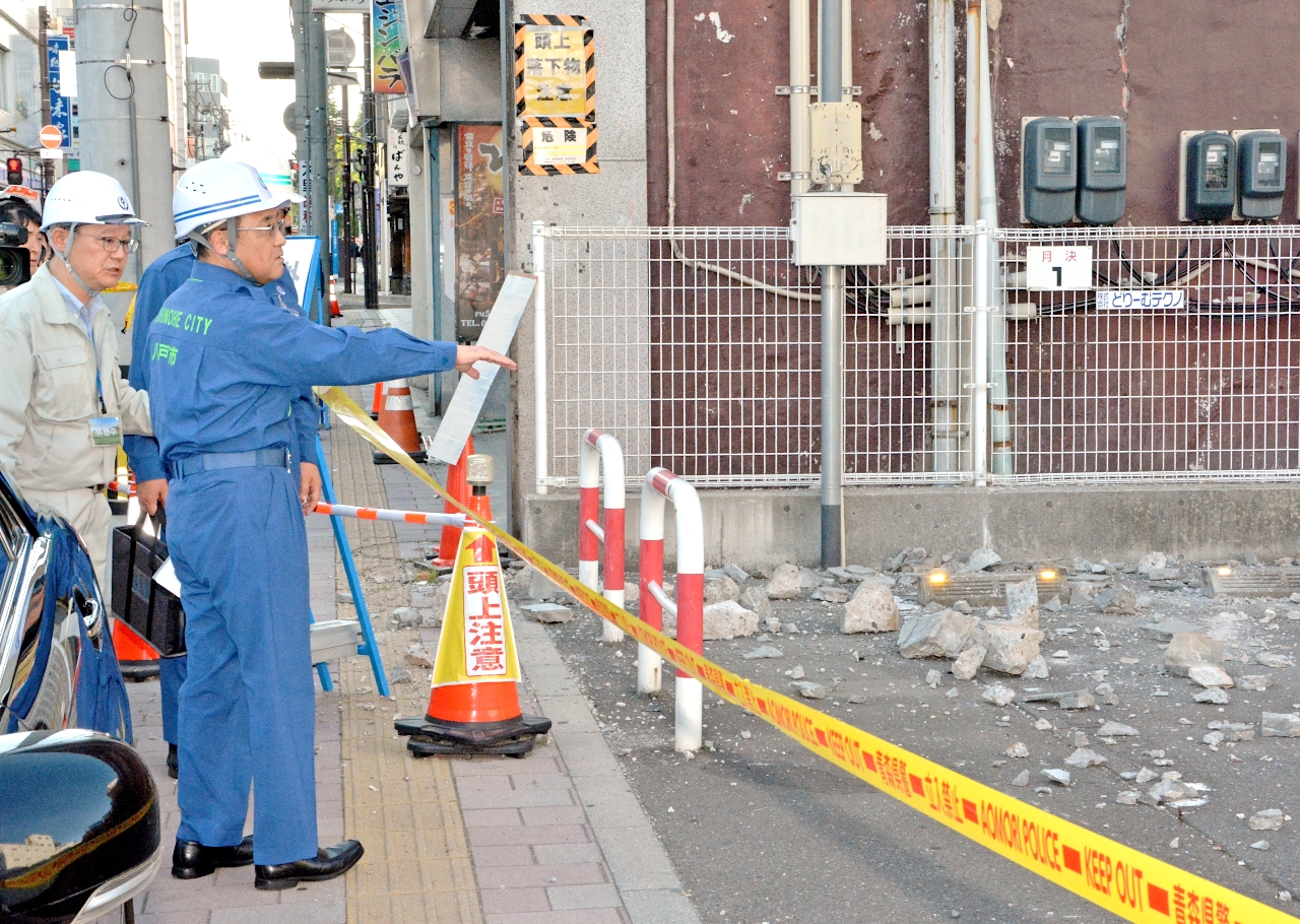 中心街の被害状況を視察する熊谷雄一市長（左から２人目）＝２５日、八戸市長横町