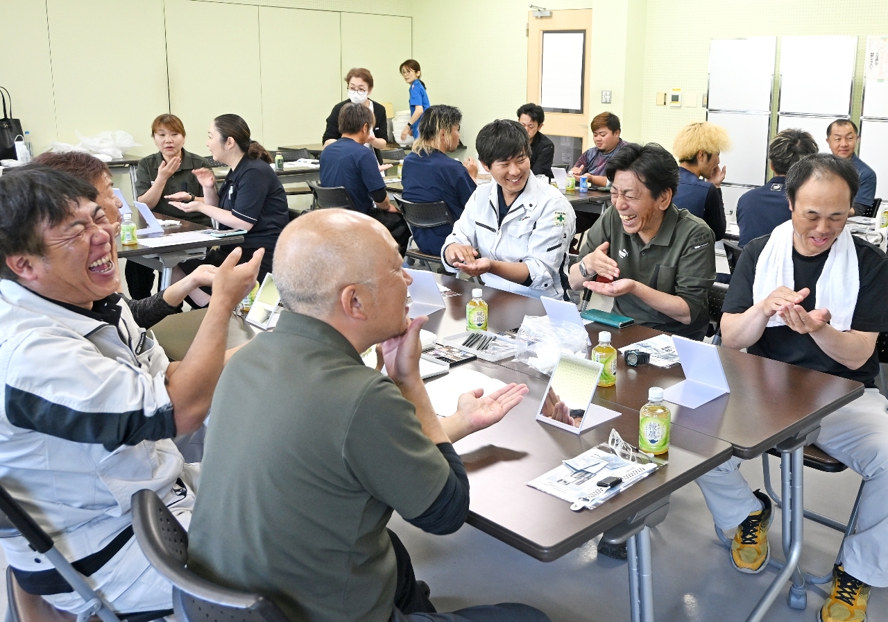 恥ずかしがりながらスキンケアを学ぶ男性従業員