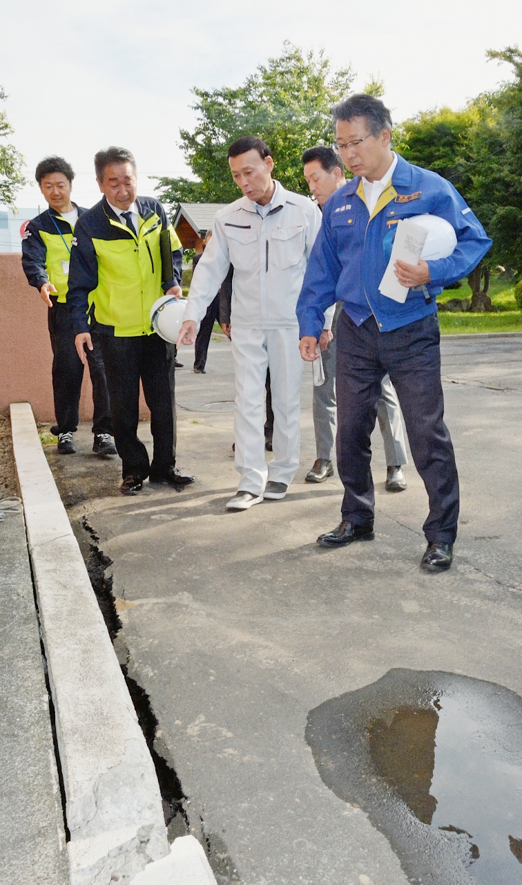 階上町役場の敷地内で地震被害の状況を確認する神田潤一衆院議員（右）ら＝２７日