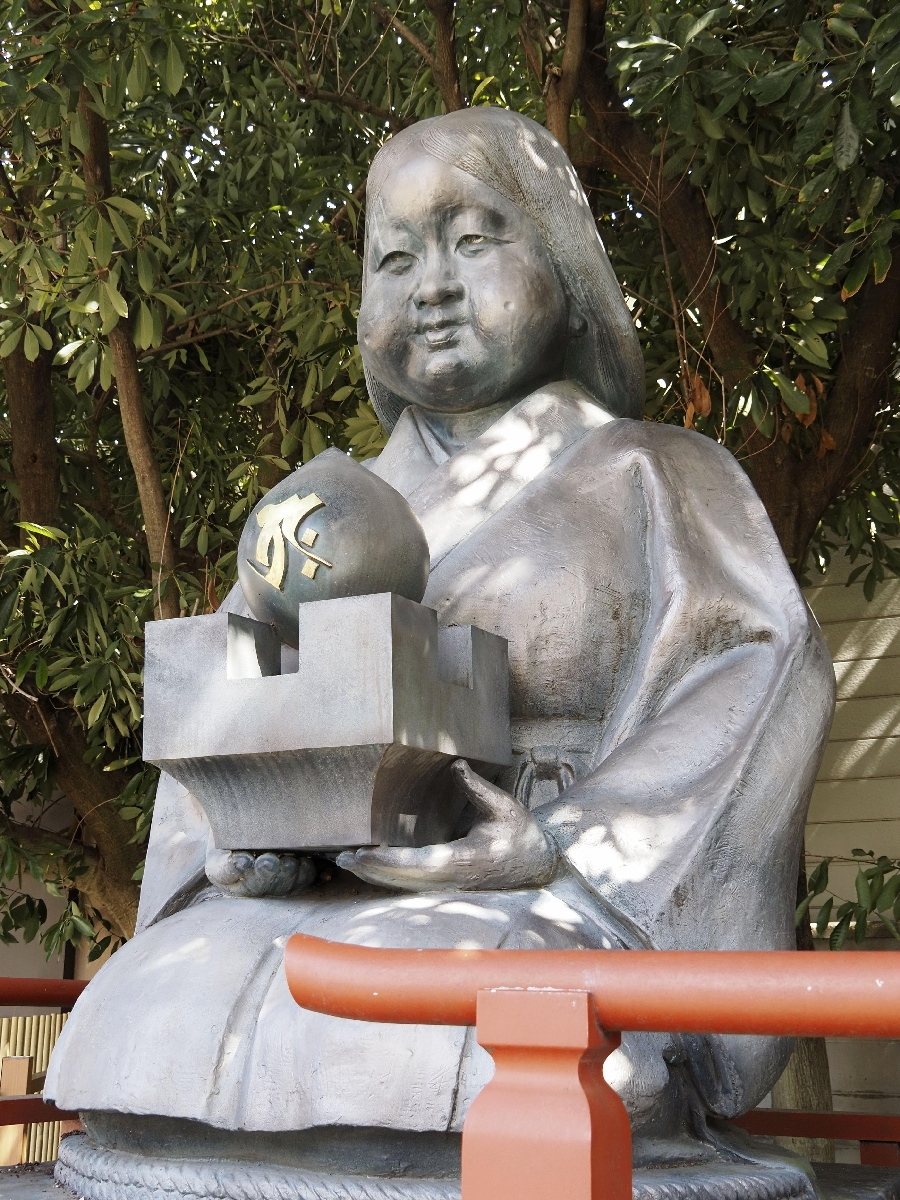 　ますがたを持ってすわるおかめの銅像＝京都市上京区の大報恩寺