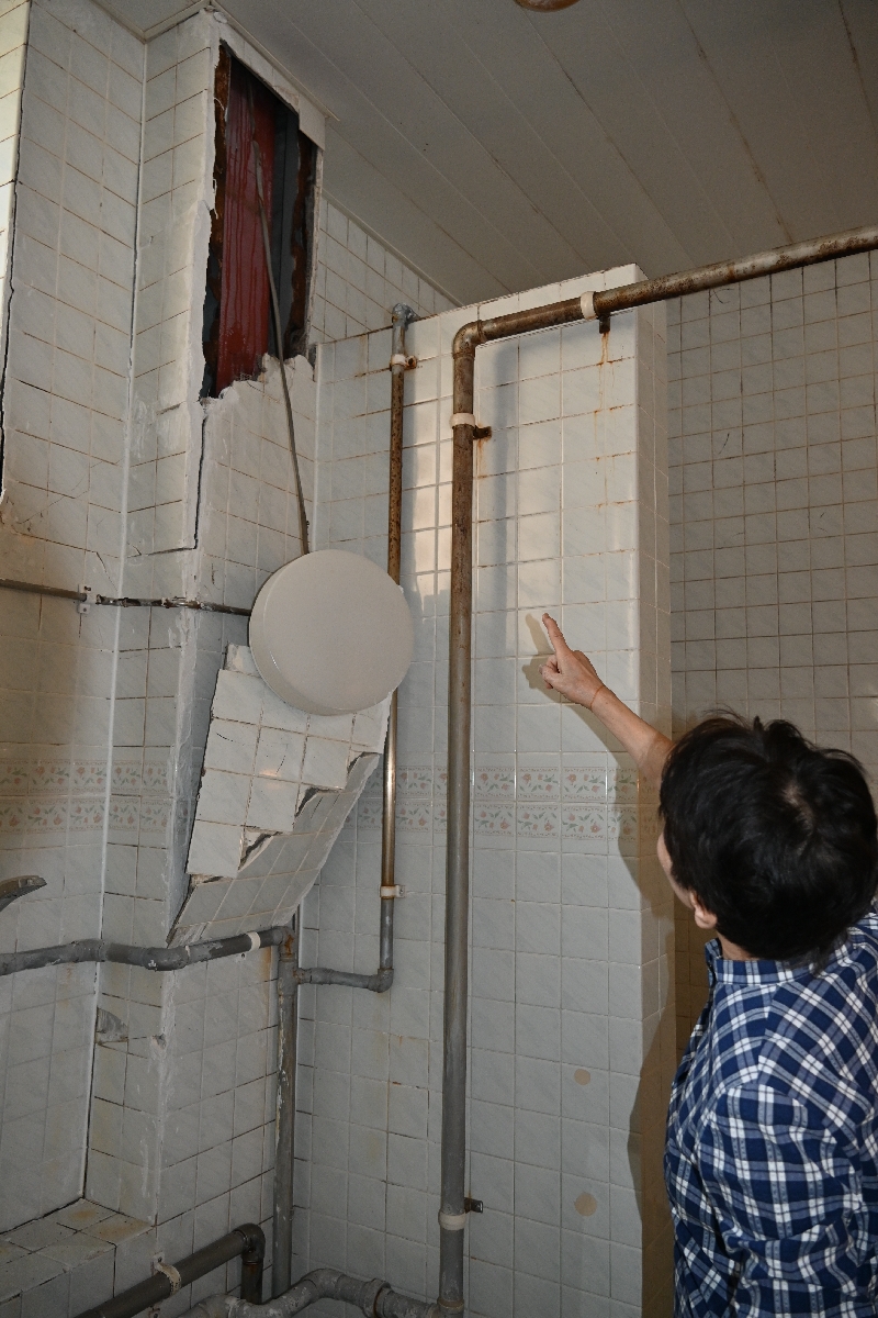 大きな揺れで壁から落下した電灯。電線一本でかろうじてつながっている=1日、八戸市の柳湯