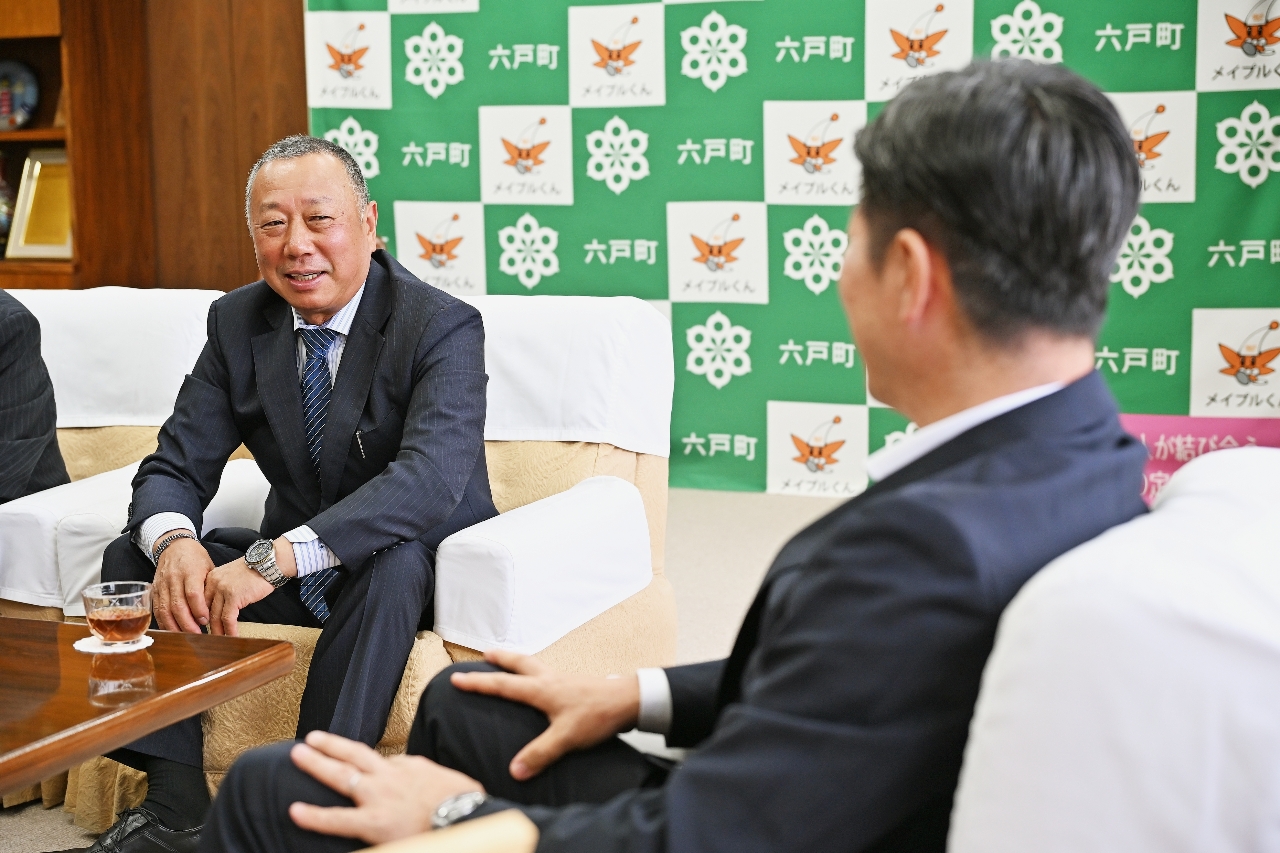 佐藤陽大町長(右)に「おいらせハーブポーク」の販売に向け意欲を語る坂岡正晴代表=2日、六戸町