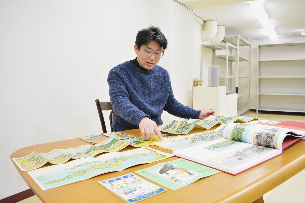 吉田初三郎の鳥瞰図について解説する小倉学館長=八戸クリニック街かどミュージアム