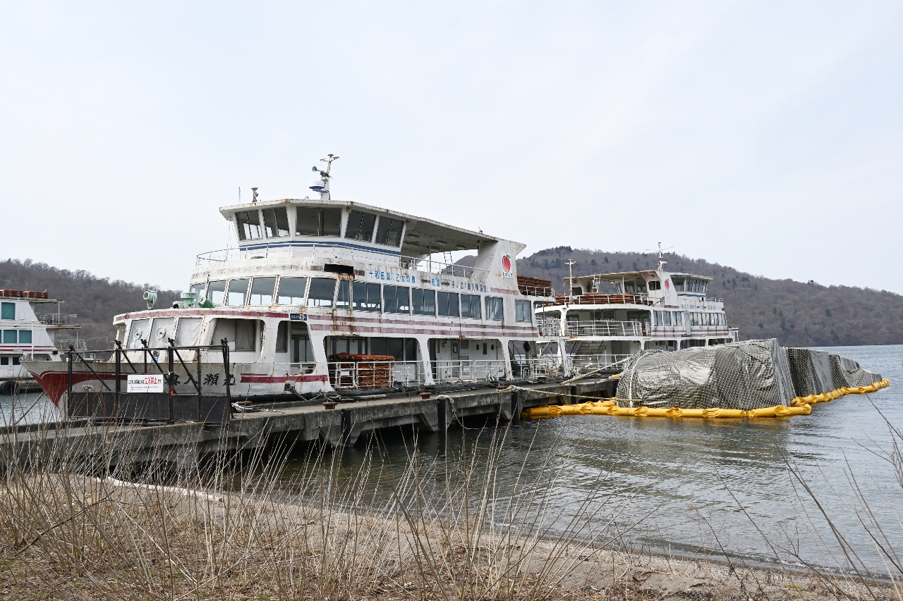 十和田湖畔宇樽部地区の桟橋に放置されている遊覧船。うち１隻は横転したままとなっている＝４月、十和田市