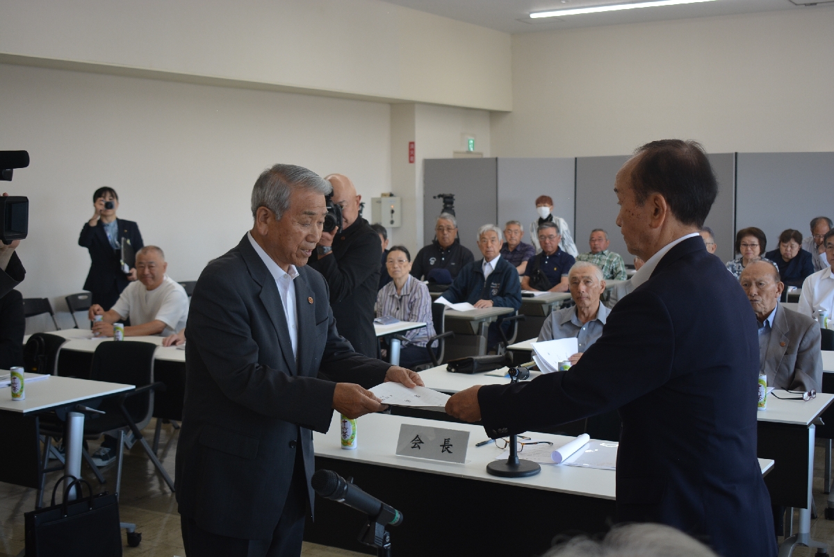 小桧山吉紀市長（右）に陳情書を提出する種市光雄会長＝６日、三沢市役所
