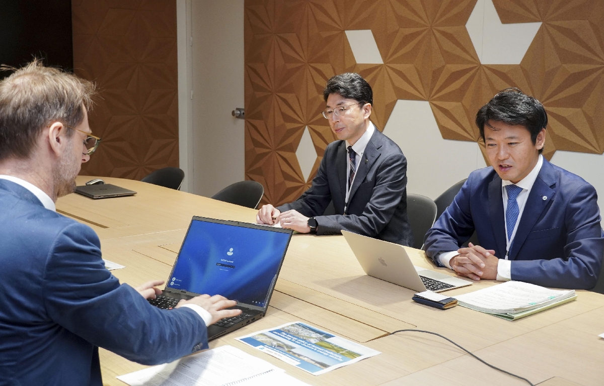 仏政府のローラン・クエニー局長(手前)と会談する青森県の宮下宗一郎知事(右)=7日、パリ(共同)