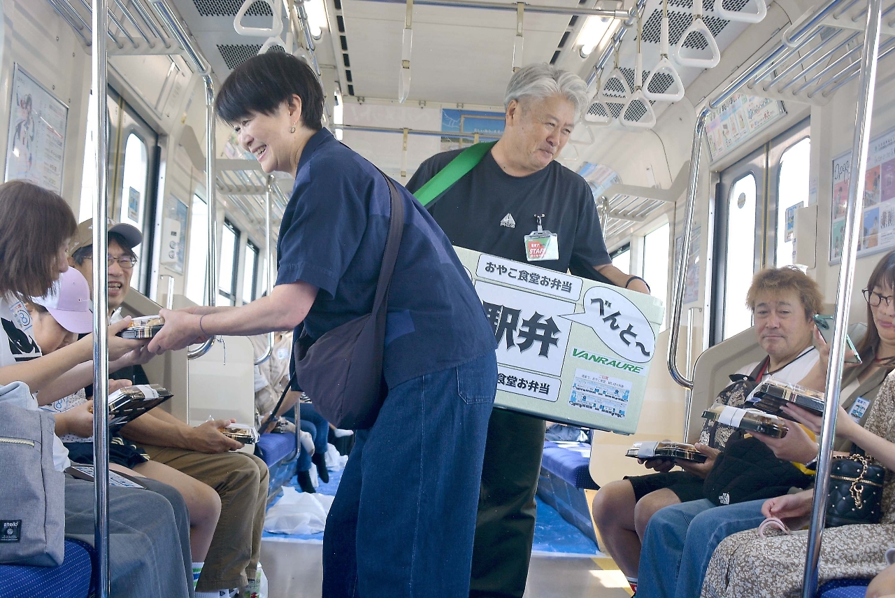 「べんと～」と駅弁売り風に弁当が配られた