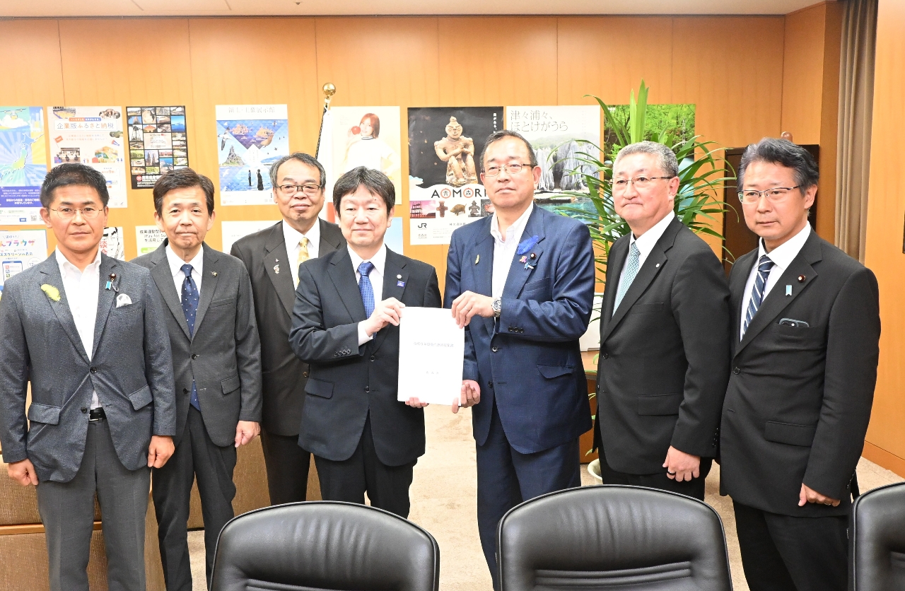 津島淳副大臣（右から３人目）に提案書を手渡す奥田忠雄副知事（同４人目）＝７日、東京都内