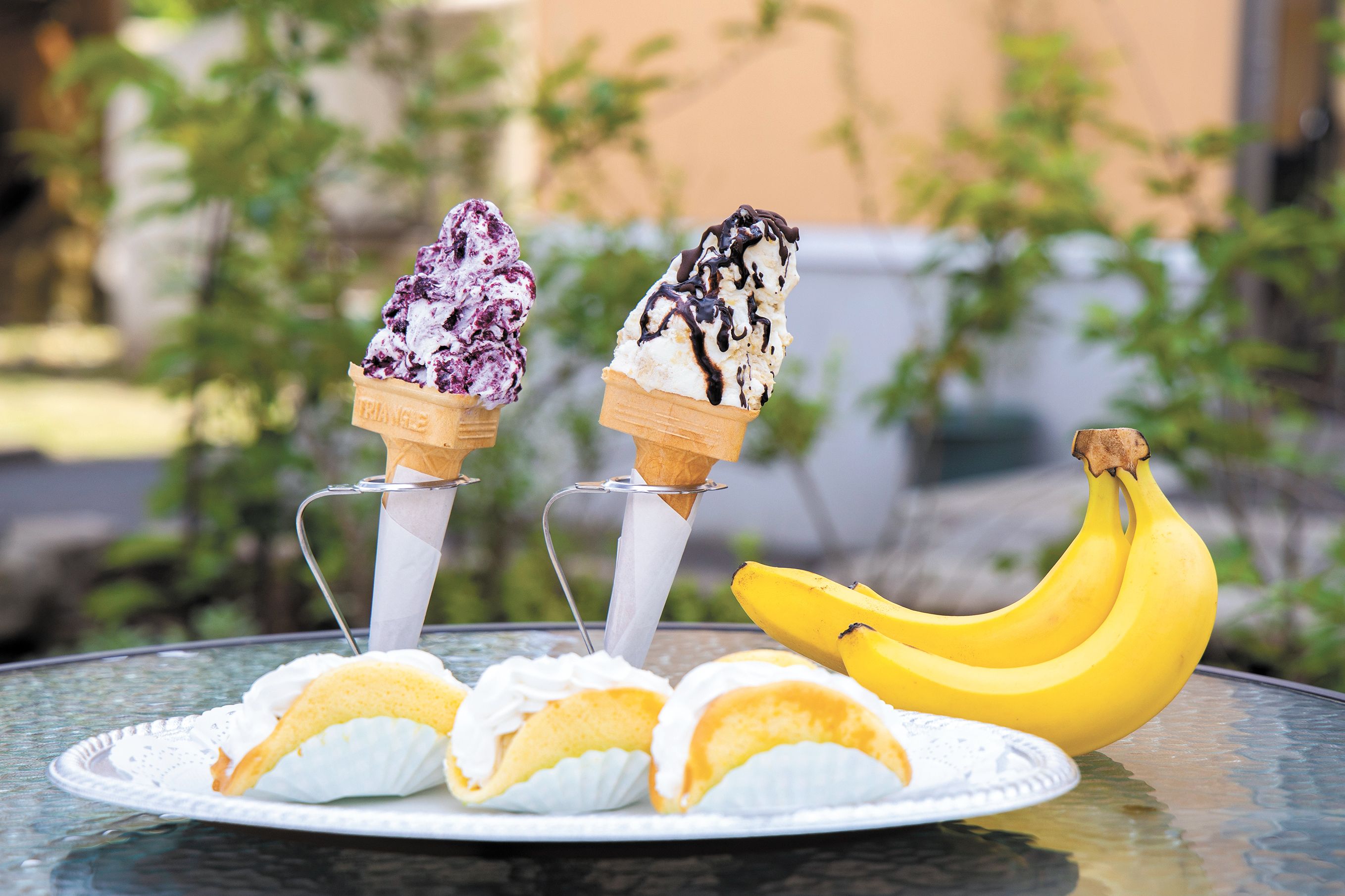 「バナナミルクアイス」（後方右）と「ブルーベリーミルクアイス」（後方左）は各450円（店内飲食は各458円）。「バナナオムレ」（手前）は１個160円