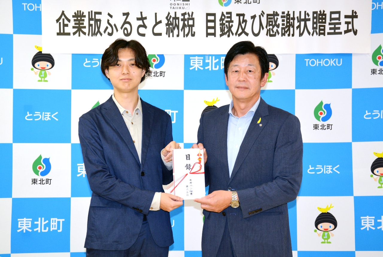 目録を手にする渡邊駿介執行役員(左)と長久保耕治町長