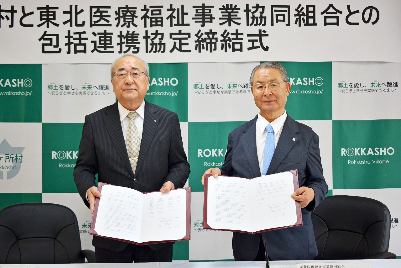 協定書を交わす橋本隆春村長(左)と田中信幸理事長=15日、六ケ所村役場