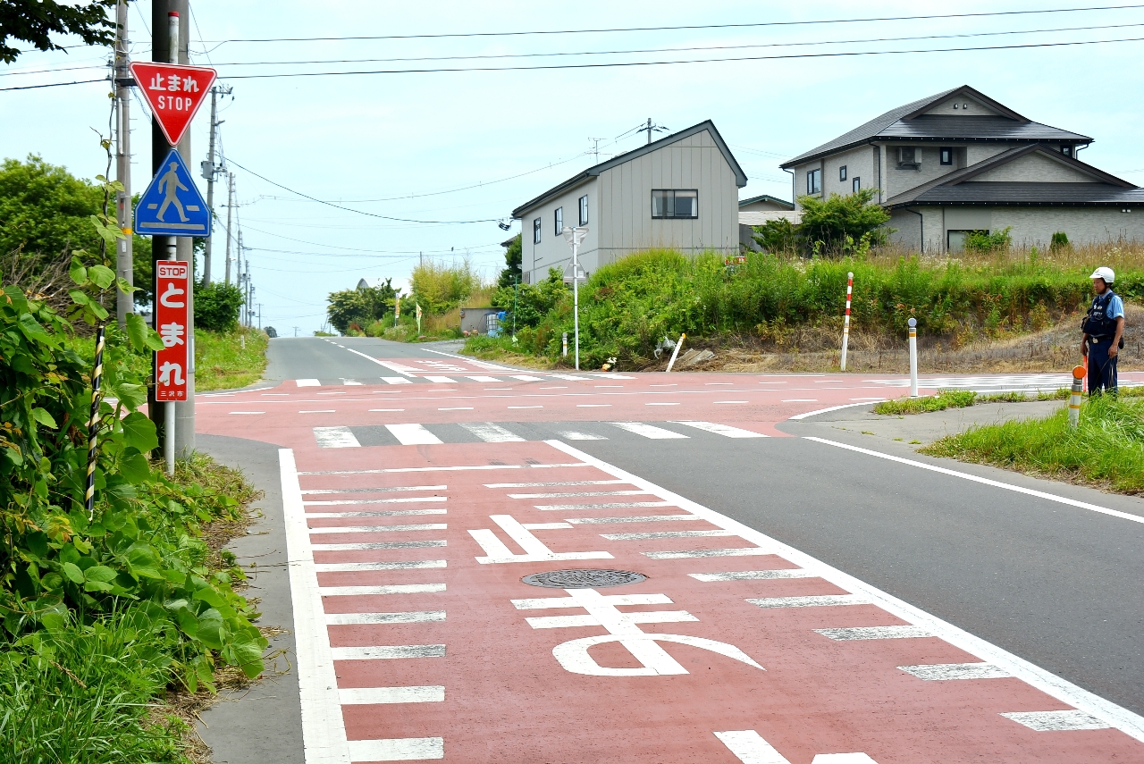 注意喚起で赤く塗装され「止まれ」と表示された交差点=10日、三沢市三沢