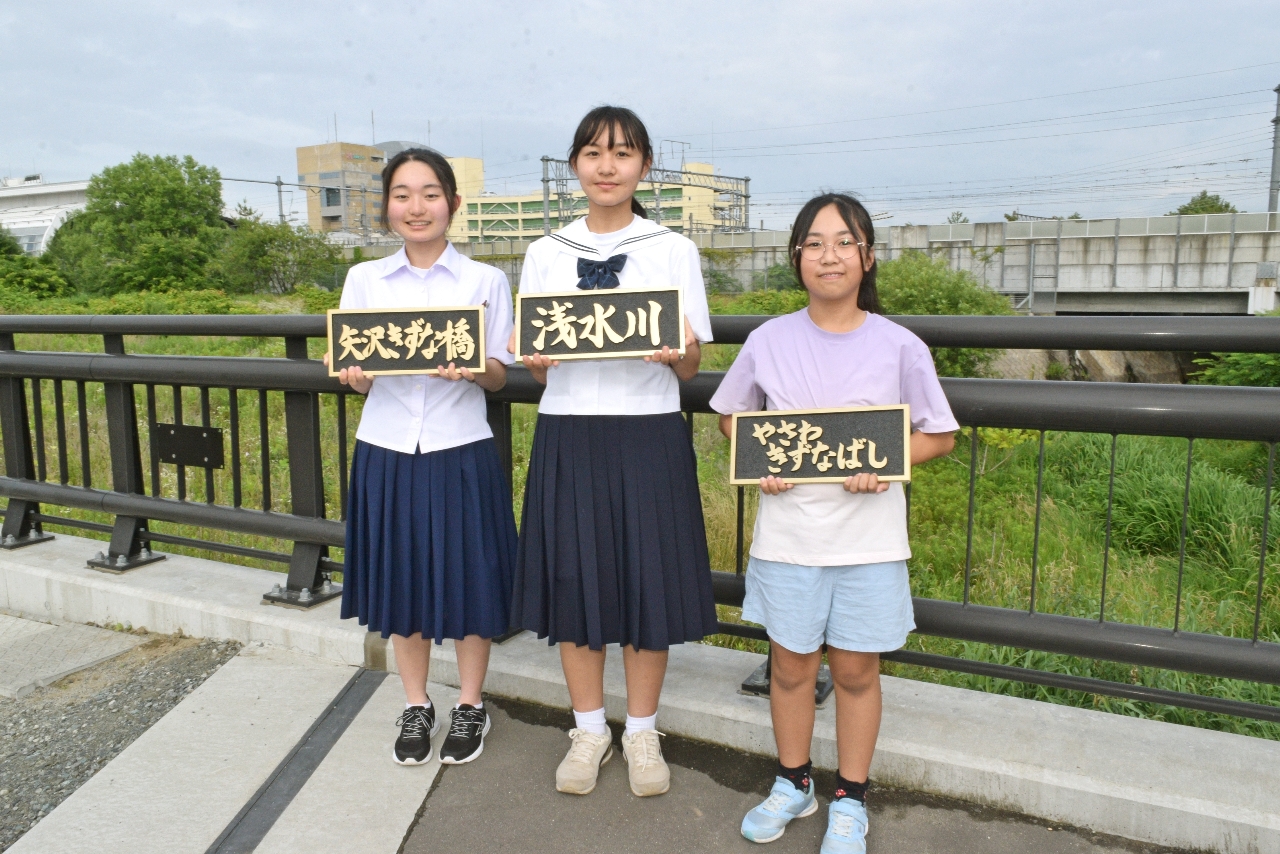 矢沢きずな橋の橋名板の書体を担当した（左から）馬渡優奈さん、真奈さん、花奈さん