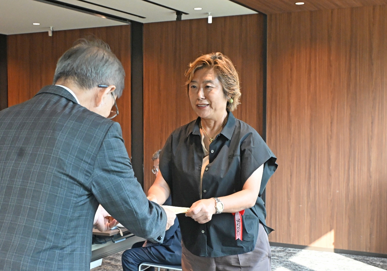 認定証を授与される町田直子さん(右)=21日、東京都内