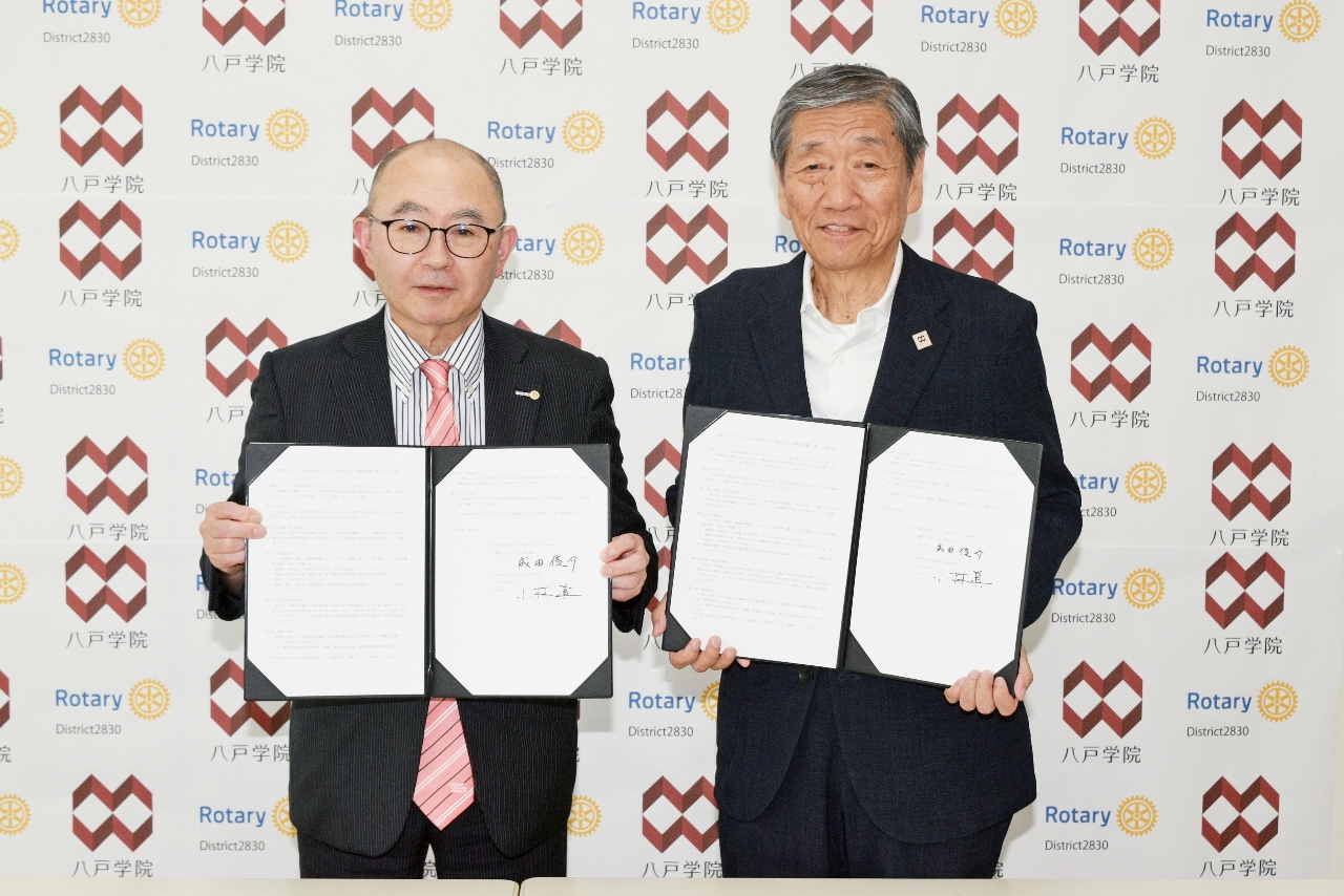 協定を締結した成田俊介ガバナー（左）と小林眞学長＝２２日、八戸学院大