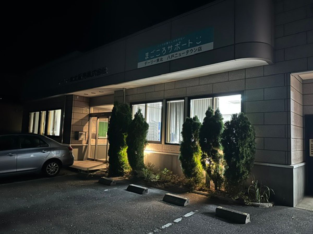暗闇に煌々と明かりのともるデーリー東北販売(株)ニュータウン店
