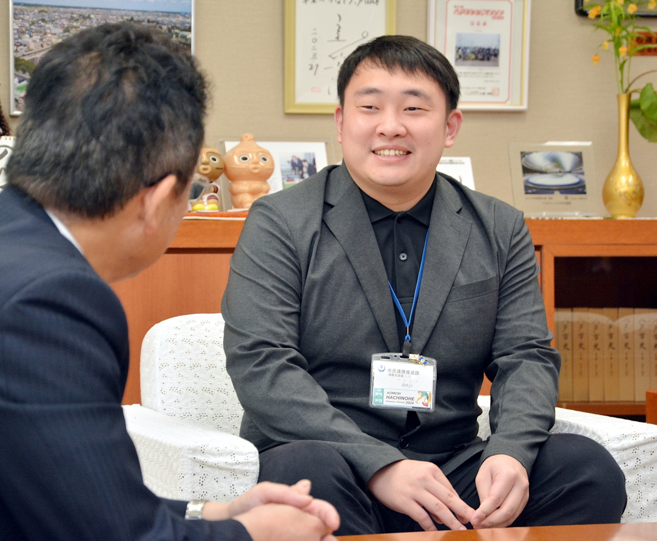 熊谷雄一市長（左）に八戸での思い出を語るジュンジ・ヤンさん