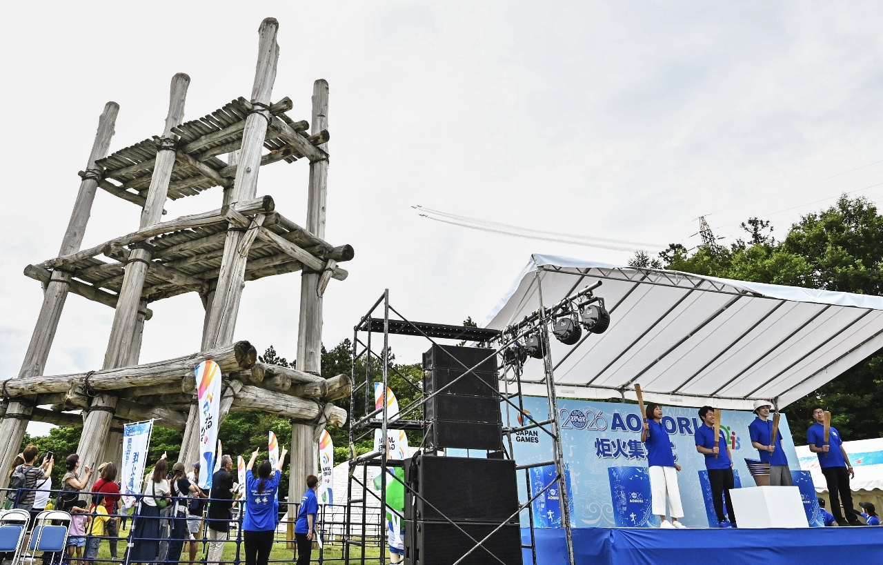 炬火集火式を華やかに飾ったブルーインパルスの展示飛行。集まった関係者が士気を高めた=25日、青森市