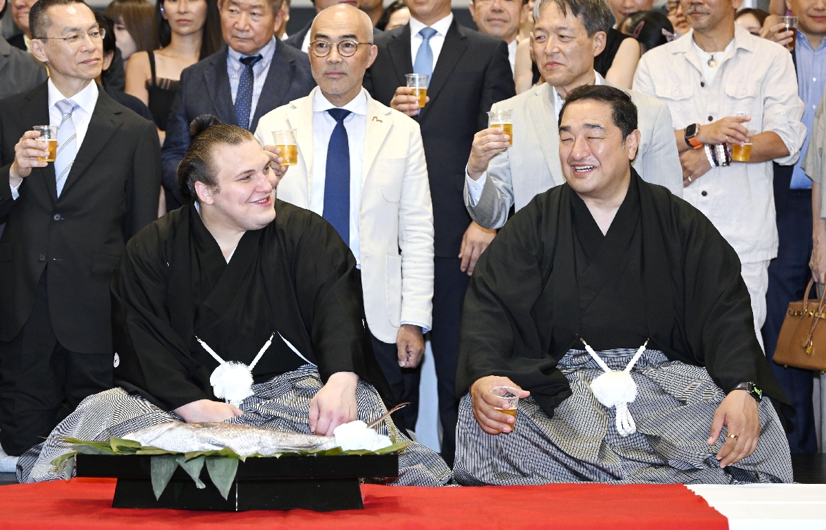 　大相撲名古屋場所で優勝し、祝勝会で師匠の安治川親方（右）と笑顔で話す安青錦＝２６日、名古屋市
