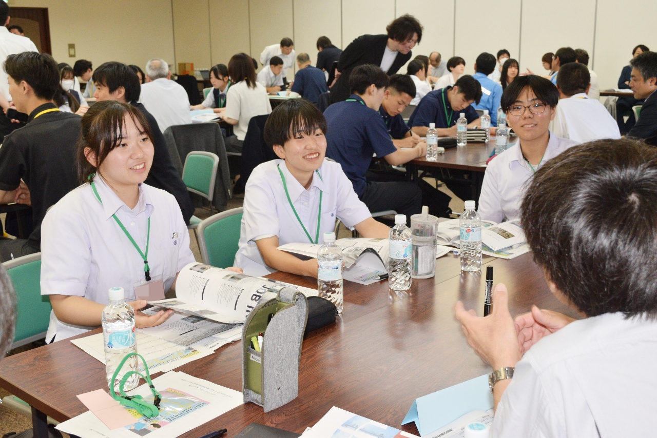 企業の担当者（手前右）から事業内容などの説明を受ける高校生＝２７日、八戸市