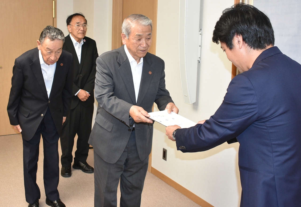 宮下宗一郎知事（右）に陳情書を手渡す種市光雄会長（右から２人目）ら＝２８日、青森県庁