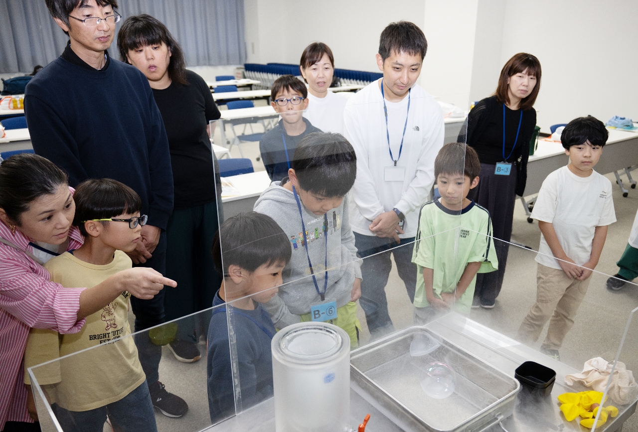 液化窒素に入れたシャボン玉が、徐々に凍る実験を観察する参加者