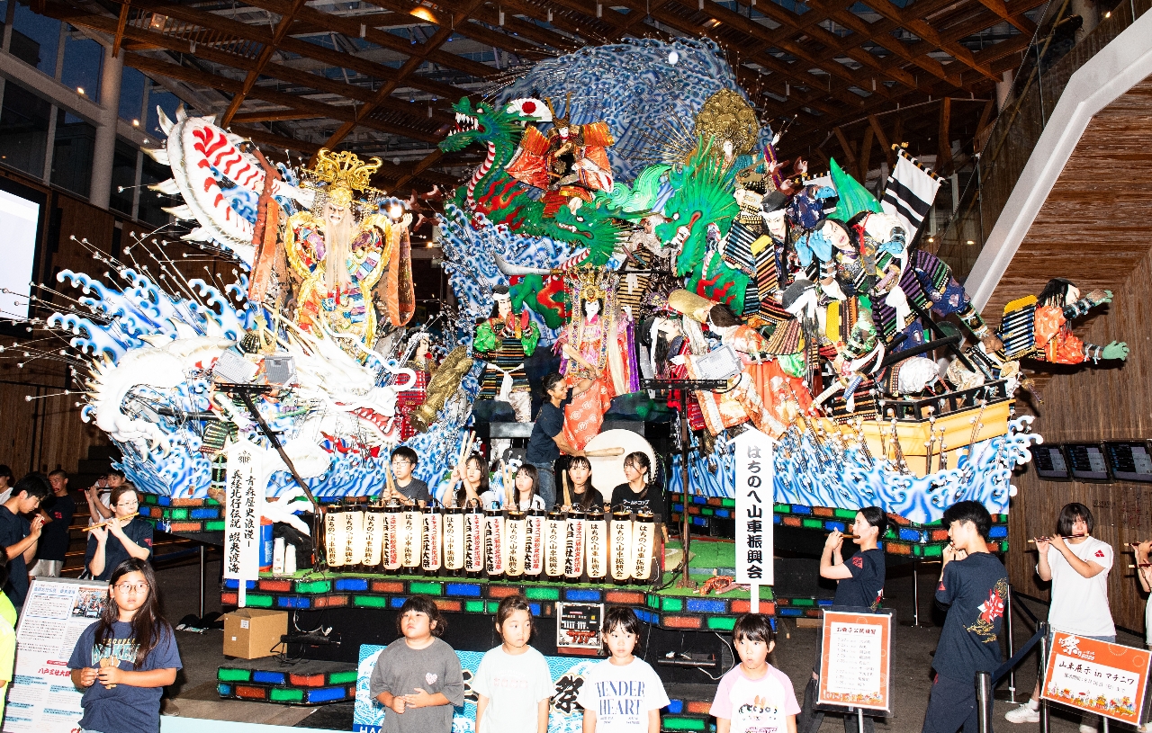 八戸三社大祭の開幕を控え、八戸市のマチニワに展示されている移動型山車の前では子どもたちが威勢の良いお囃子を響かせている＝２８日（大西桂介撮影）