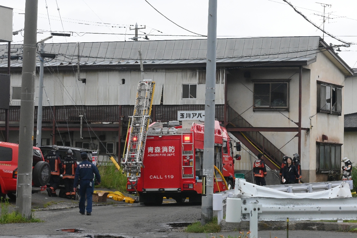 ２階部分から出火し、消防車両が集まる火災現場＝２９日午後１時４０分ごろ、青森市浜田玉川