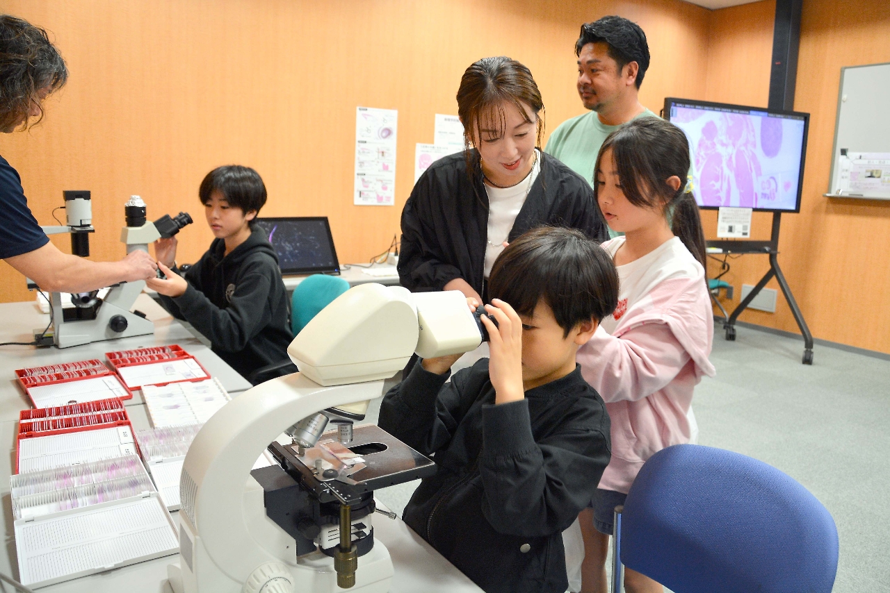 環境科学技術研究所の先端分子生物科学研究センターで顕微鏡をのぞく子どもたち