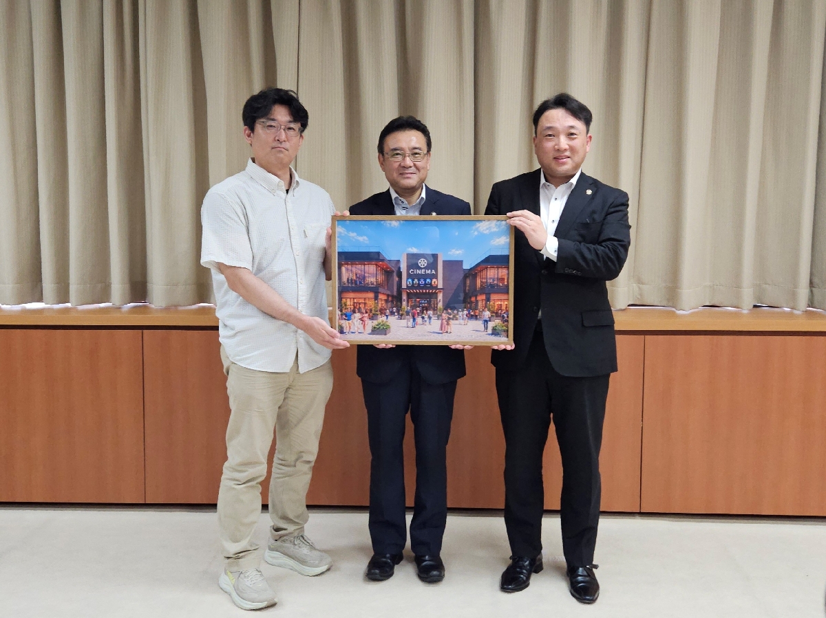 施設のイメージ図を手に記念写真に収まる関係者。右から田名部智之社長、熊谷雄一市長、小倉学館長=31日、八戸市庁