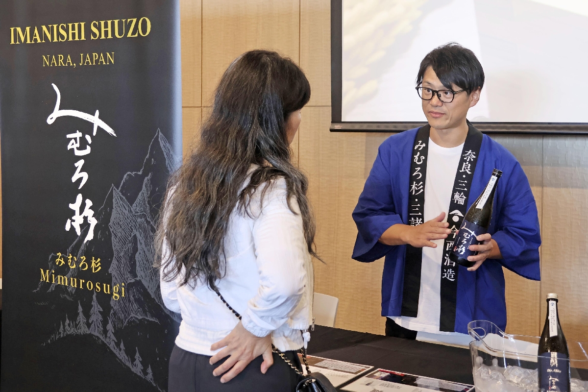 　日本酒試飲会で酒を振る舞う今西酒造の関係者（右）＝７月３１日、米ロサンゼルス（共同）