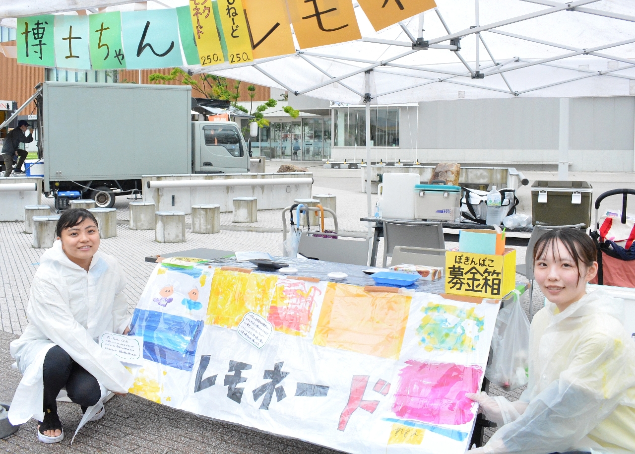 レモネードスタンドを企画した奥井ゆうかさん(左)とスタッフ。カラフルな看板は購入者に人気だった