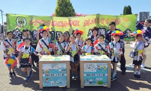 【八戸三社大祭】創立150周年の根城小児童らが賣市に参加　記念の横断幕掲げ“拾い箱”も設置