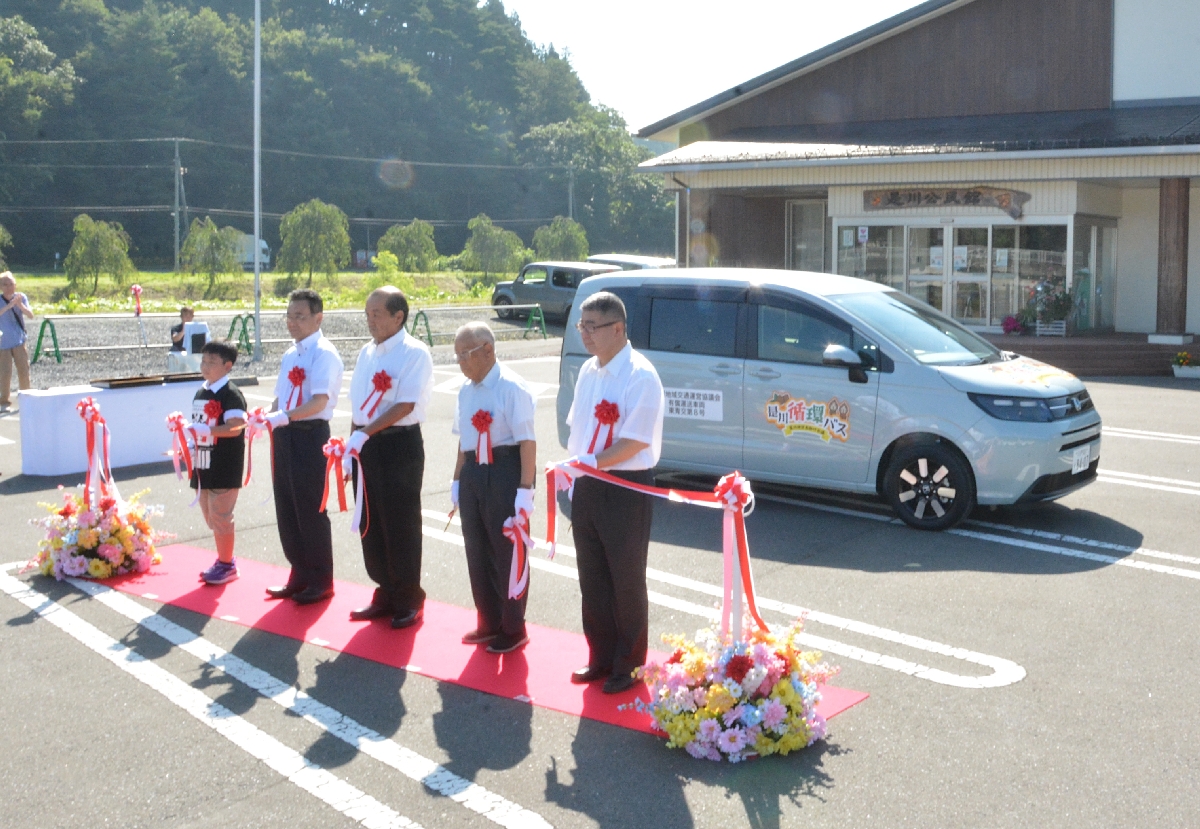 車両の前でテープカットし、運用開始を祝う関係者＝５日、八戸市是川公民館