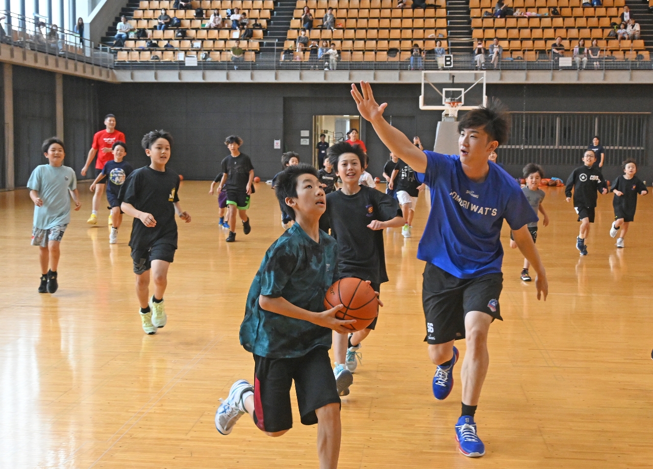 プロ選手のディフェンスをかいくぐってゴールを狙う小学生