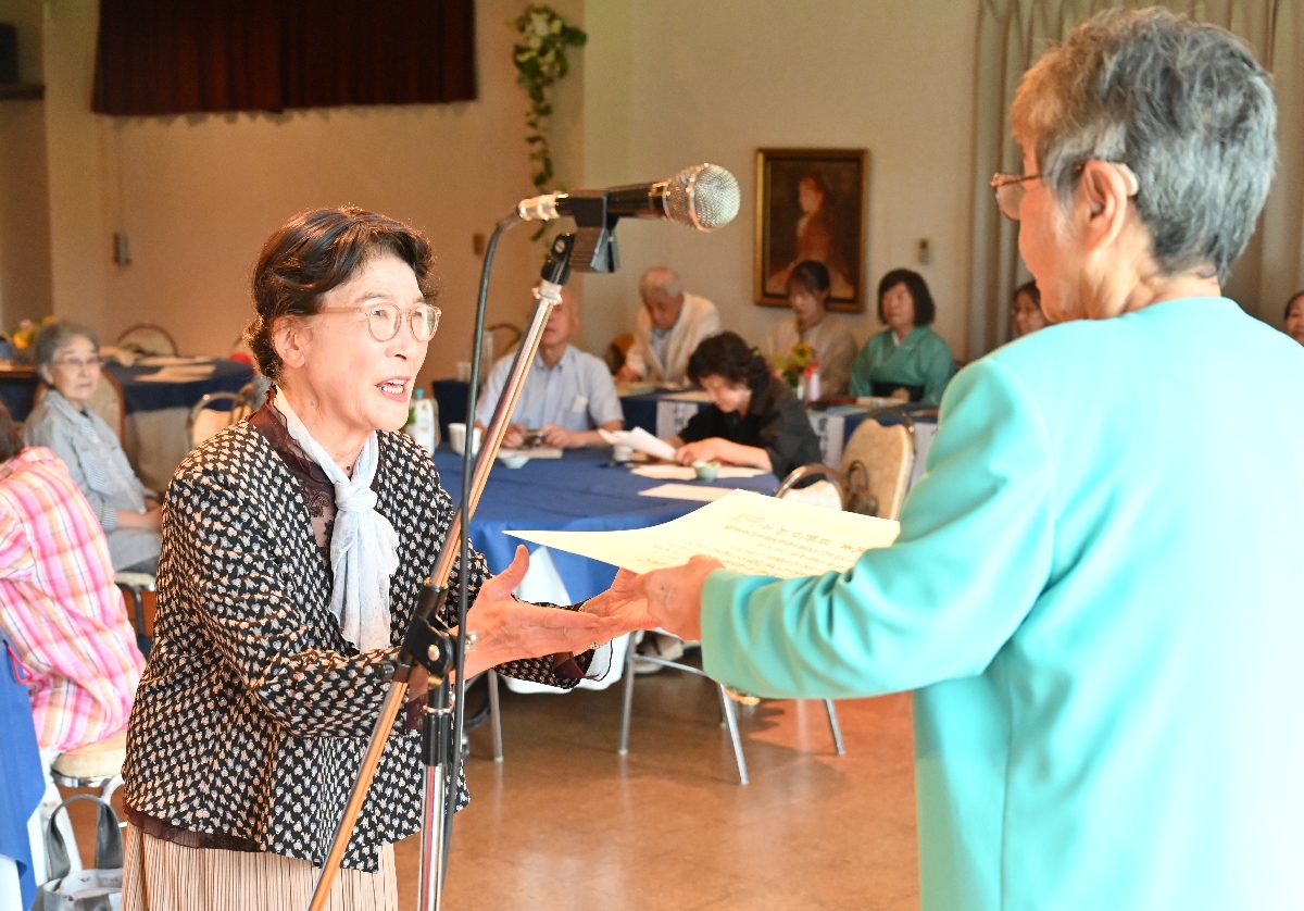 日野口和子さんの選者賞を受ける田中恭子さん(左)