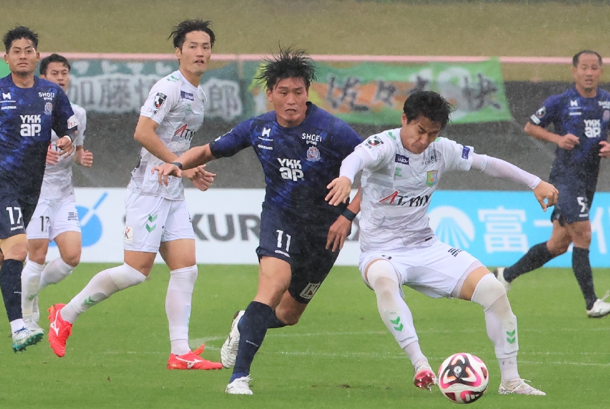 【カターレ富山―ヴァンラーレ八戸】前半、相手選手と競り合う八戸の蓑田広大(手前右)=2024年11月17日、富山県総合運動公園陸上競技場