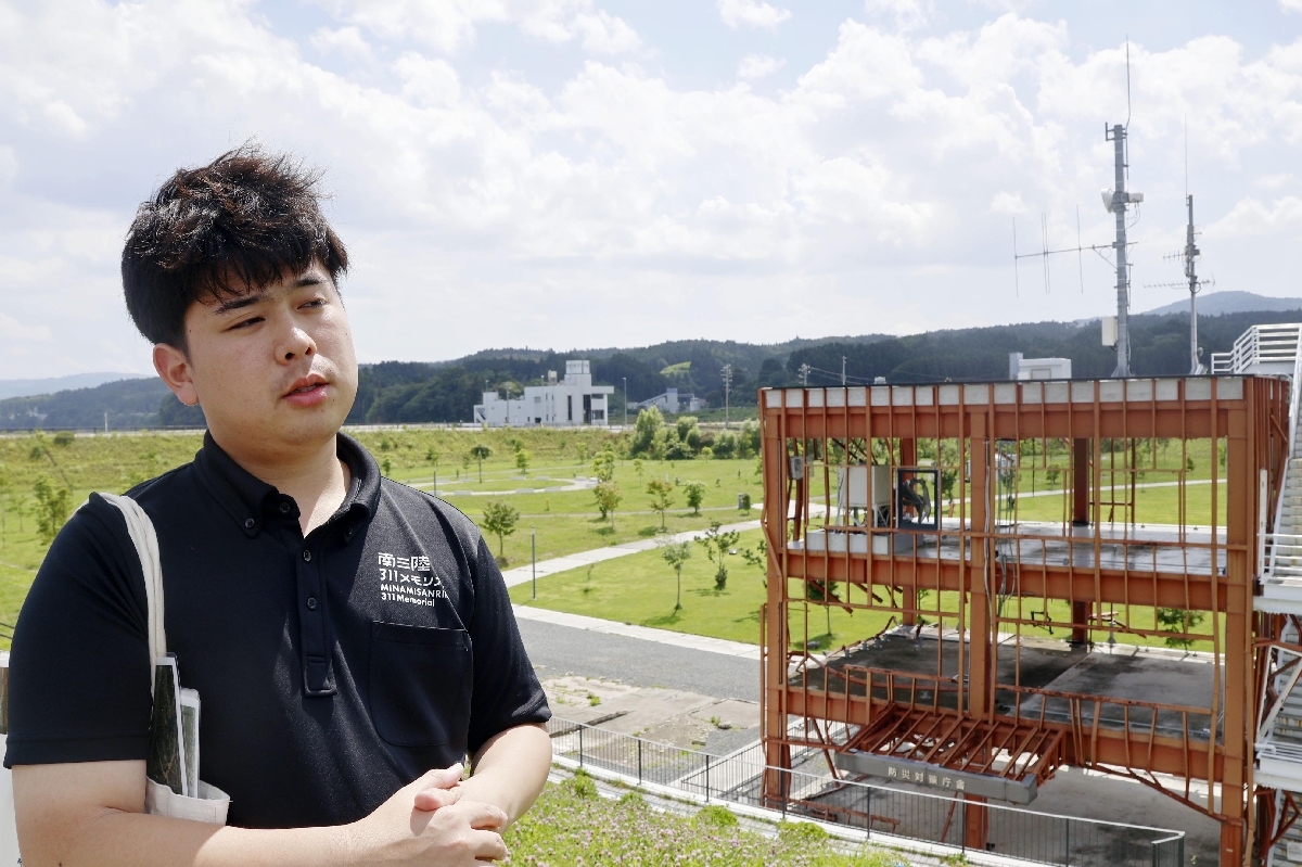 　宮城県南三陸町の旧防災対策庁舎を案内する畠山興斗さん＝７月