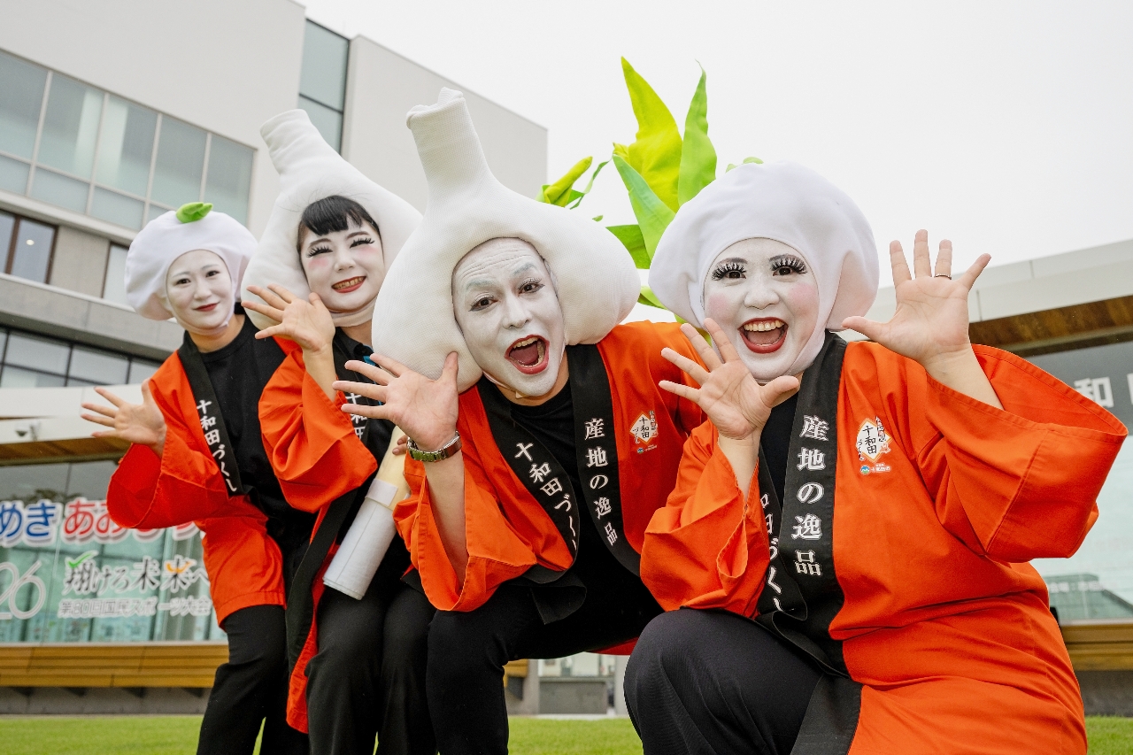 白塗りの顔に十和田市特産のニンニクのかぶり物を付けた市職員による4人組キャラクター「十和田にんにく娘」=12日、十和田市役所