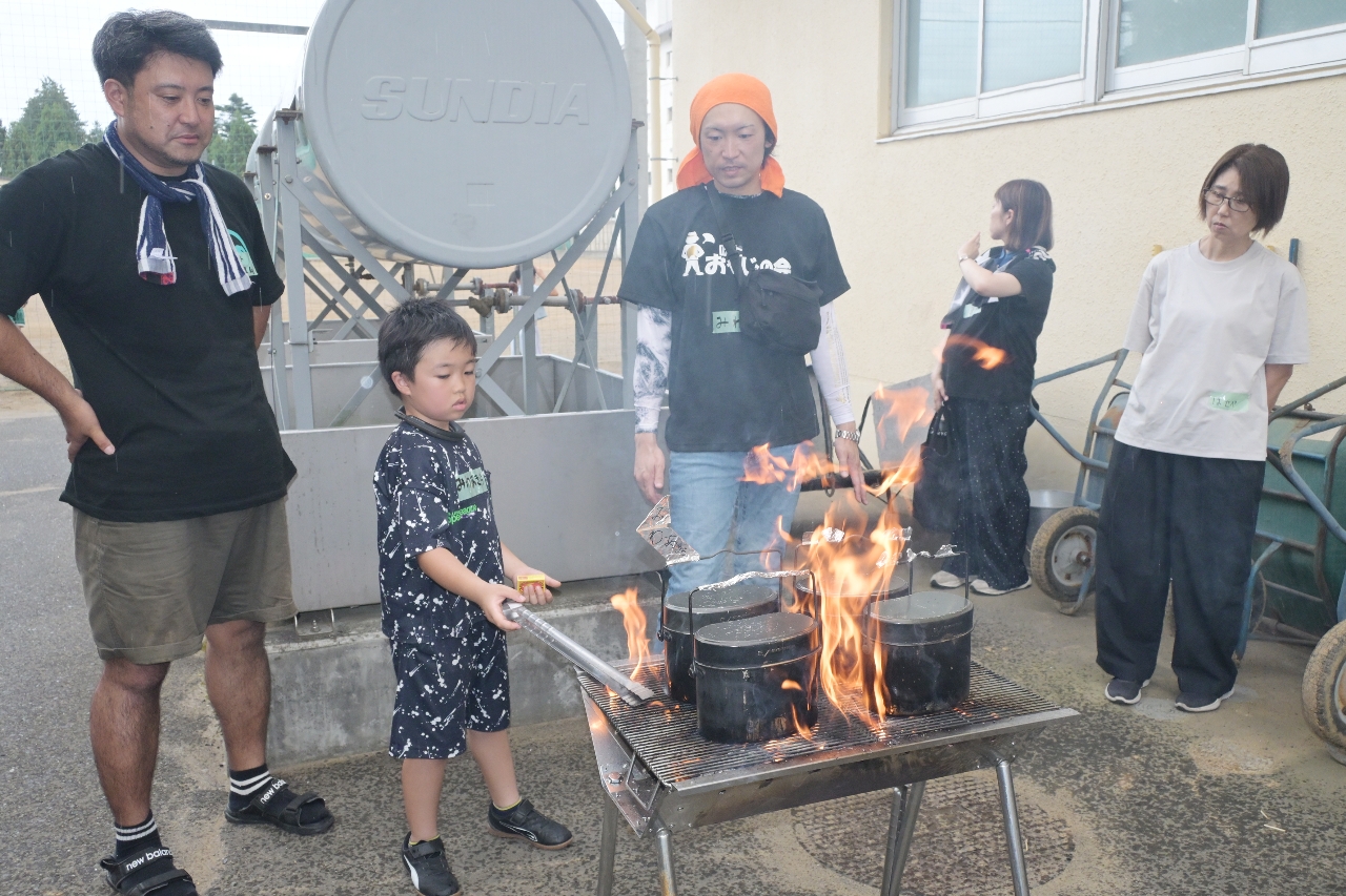 たき火で飯ごう炊飯をする参加者