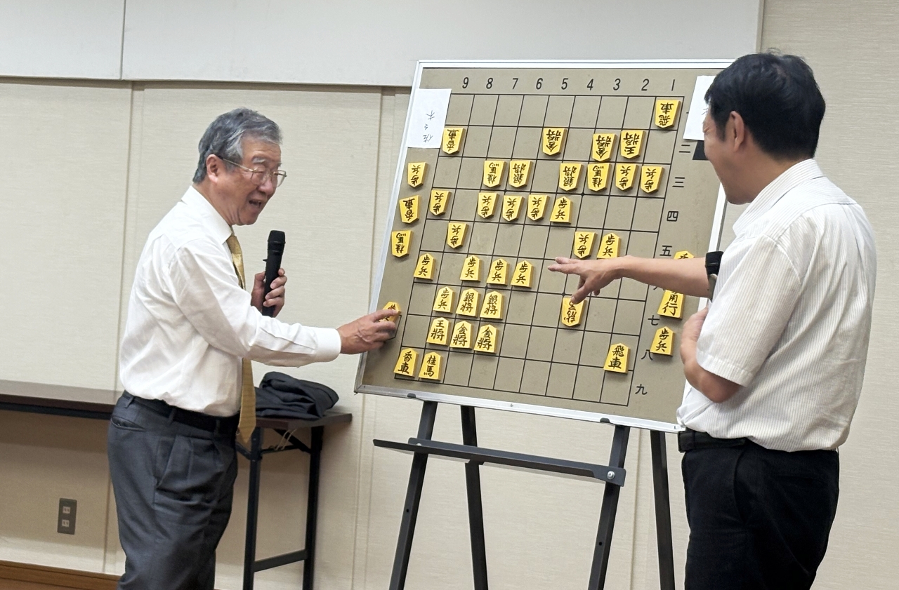池田修一杯決勝の大盤解説をする青野照市九段（左）