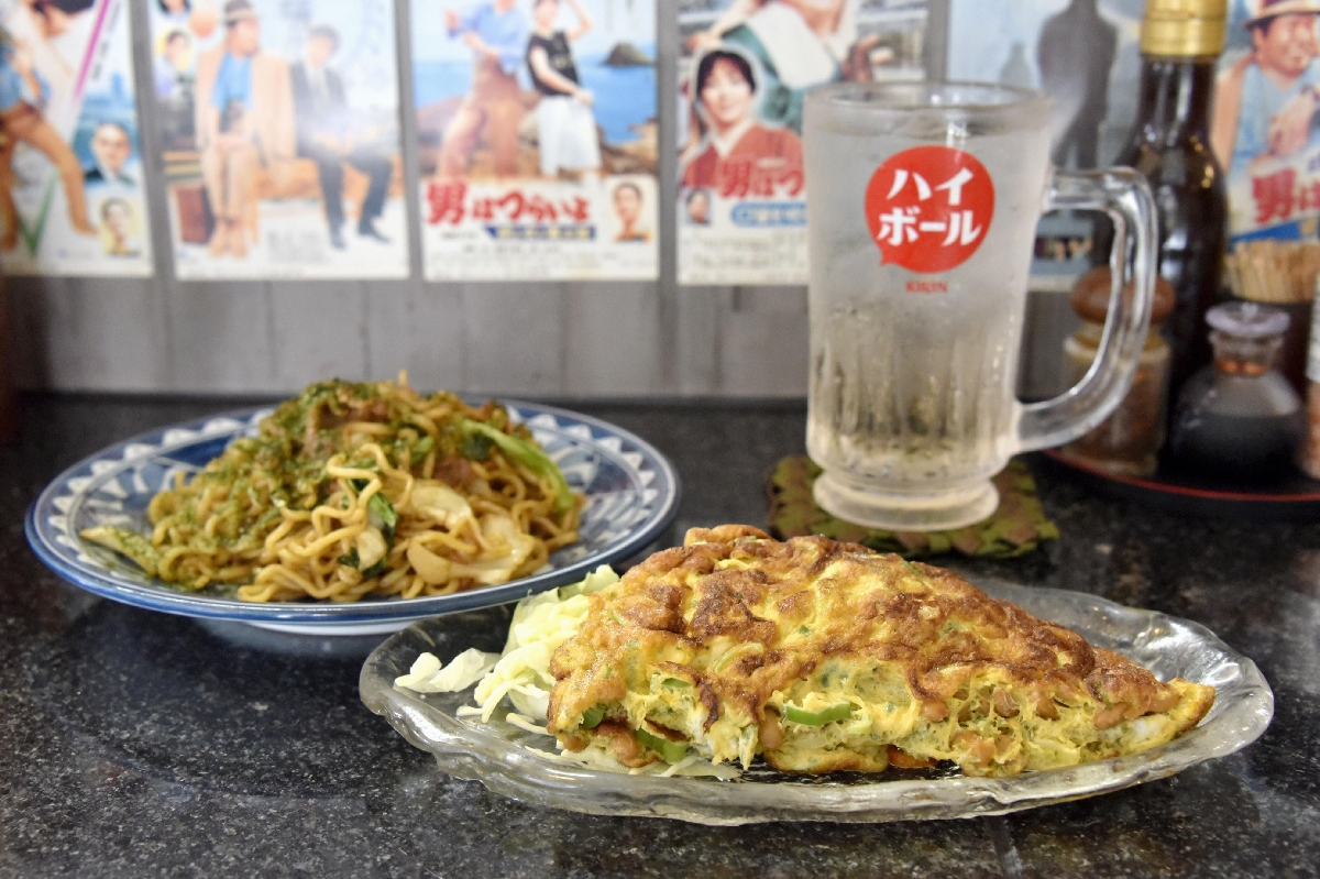 「酒場 春」の納豆オムレツ(手前)と焼きそば=東京都葛飾区