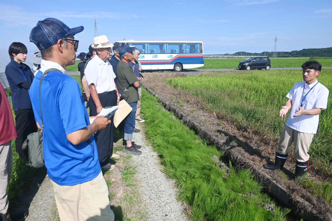 現地視察で松波寿典さん(右)の説明を聞く参加者=18日、五戸町