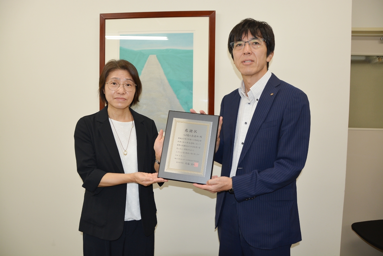 丸山佐知子部長（左）から感謝状を受ける向井俊晴専務理事＝１９日、八戸商工会議所