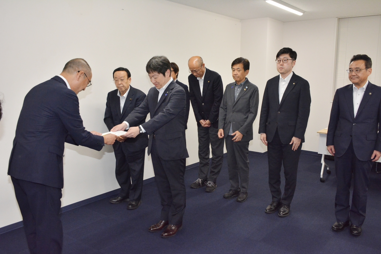 角谷公博本部長（左）に要望書を手渡す奥田忠雄副知事ら青森県内の関係者＝１９日、青森市