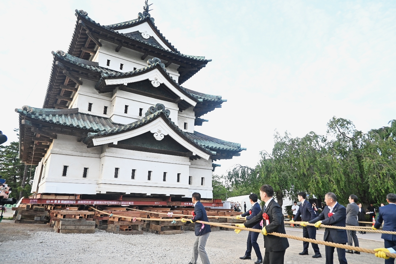 天守の曳初めを行う来賓者＝２１日、弘前市