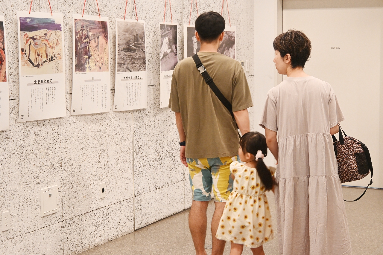 原爆の恐ろしさを伝えるパネル展示に見入る来場者