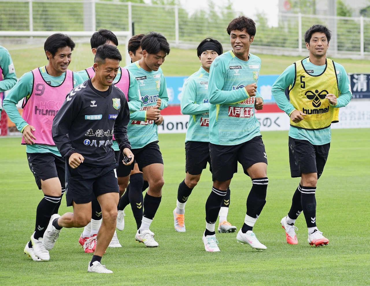 リラックスした表情で調整を行うヴァンラーレ八戸の選手ら＝２７日、八戸市プライフーズスタジアム